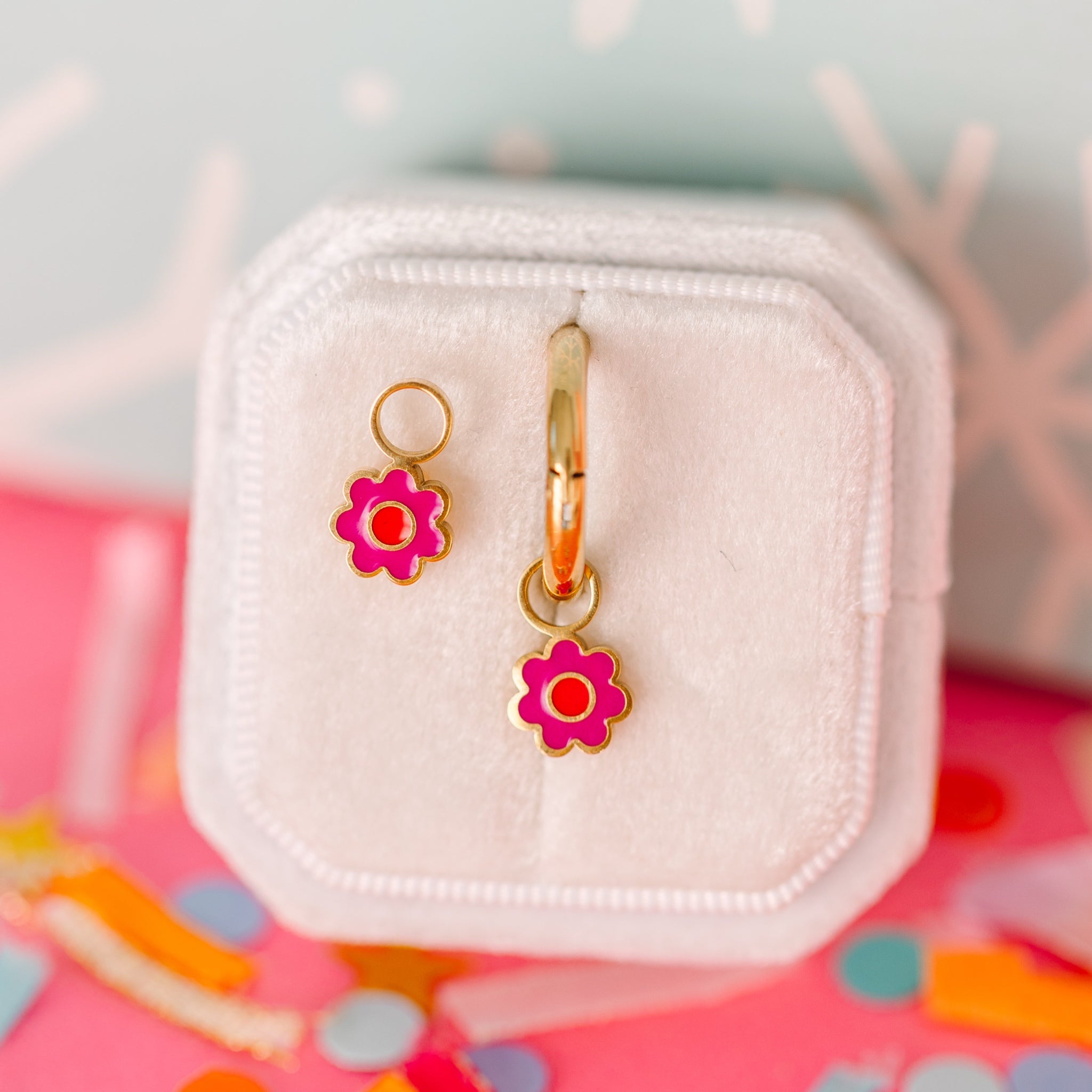 Hot pink flower with orange center connected to hoop to hang on huggies